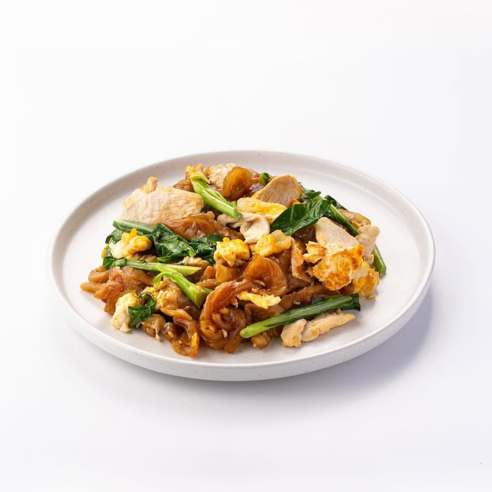 Skye Thai's Pad See Ew with wide noodles, chicken, egg, and green vegetables on a white plate.