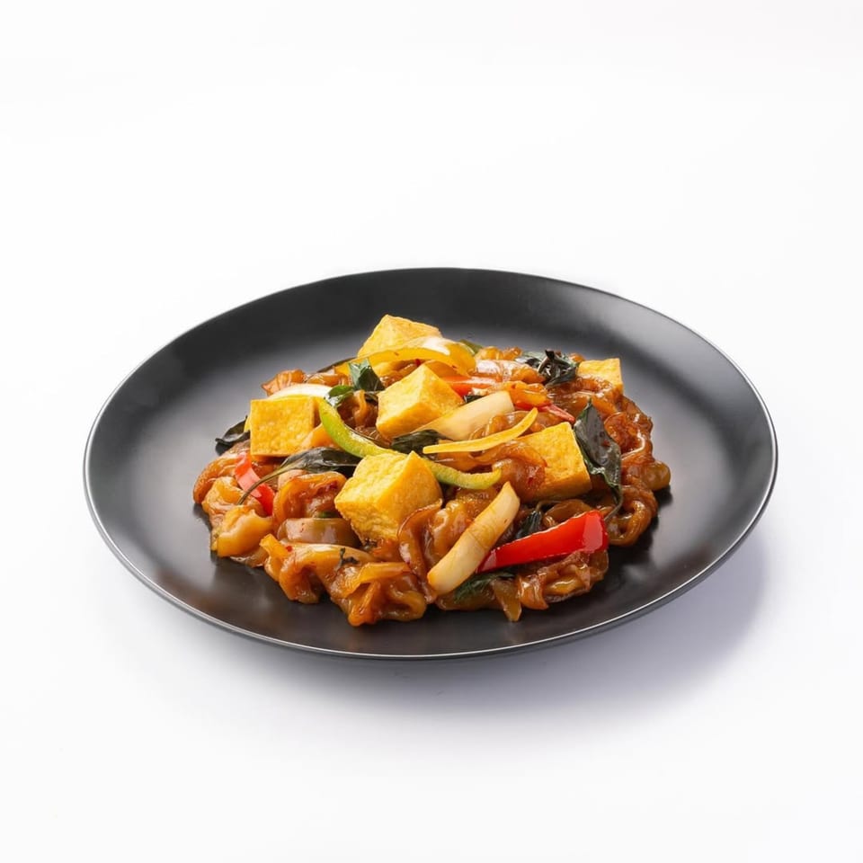Skye Thai's Pad See Ew with tofu, bell peppers, and basil on a black plate.